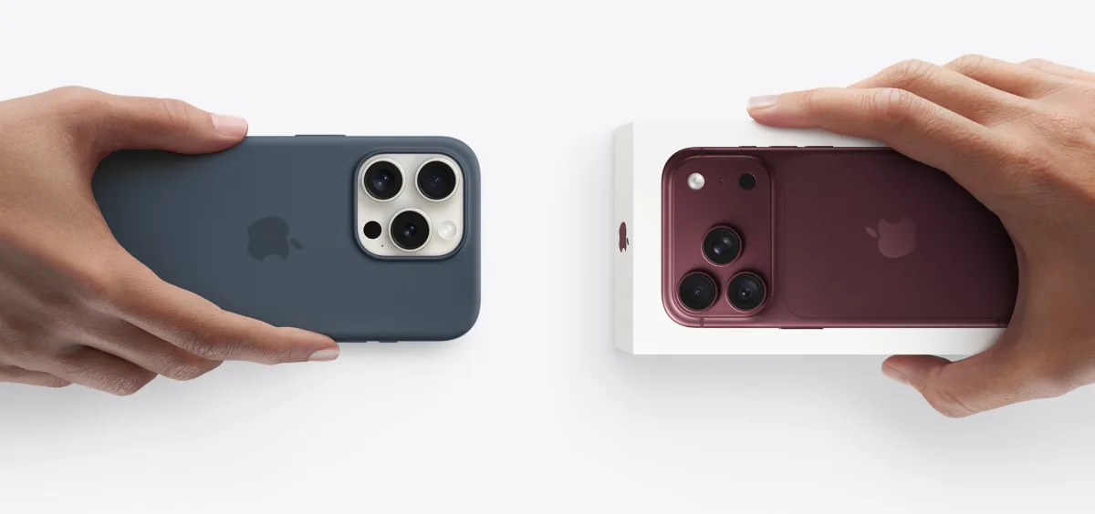يدان لشخصين يتبادلان جهازي iPhone، إحداهما تمسك بجهاز iPhone 11 والأخرى تمسك بعلبة iPhone 17e