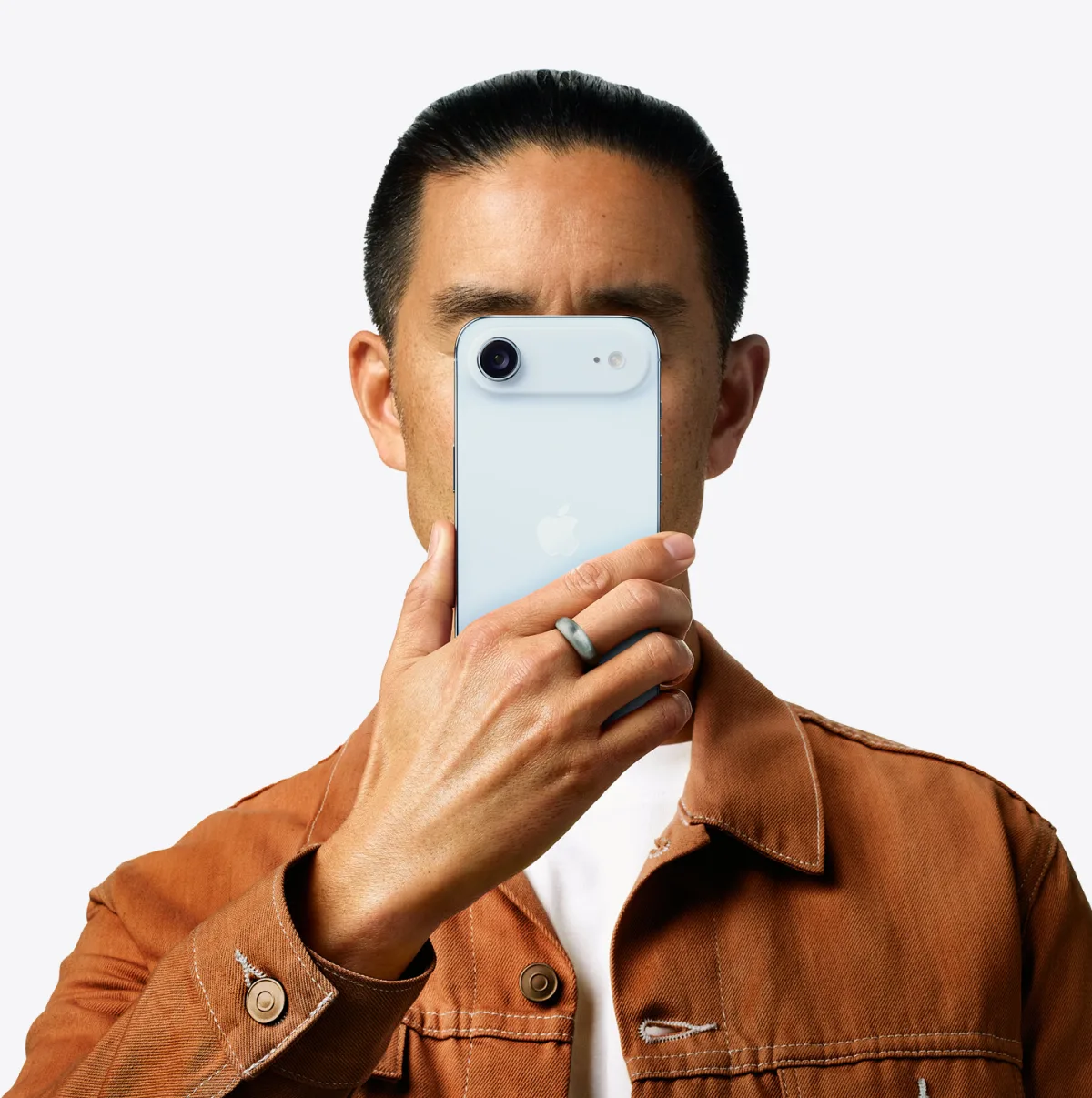 شخص يحمل iPhone Air بلون أزرق سماوي أمام وجهه ويظهر الجهة الخارجية الخلفية، ونظام الكاميرا المزدوجة في الزاوية العلوية اليسرى